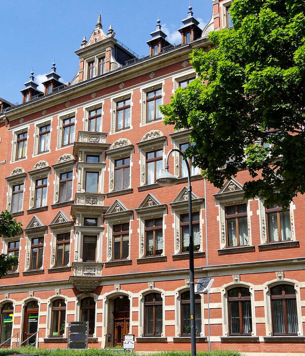 Repräsentatives historisches Gebäude aus der Gründerzeit mit roter Klinkerfassade, aufwendiger Stuckverzierung und hohen Fenstern, teils von Bäumen beschattet. Unternehmenssitz der H-A-S Service GmbH